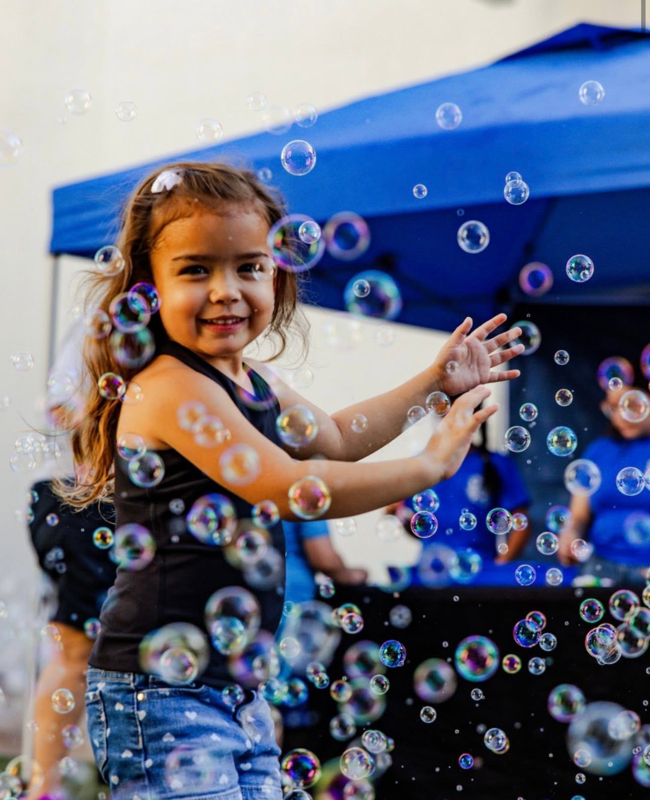 A young girl surrounded by bubbles at a Points Up bubble party